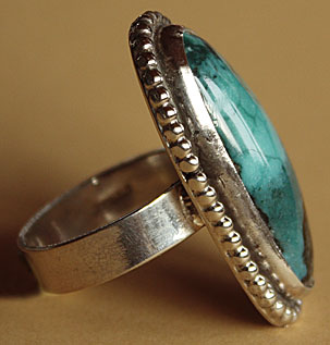 La turquoise de cette bague south western country est entourés de gouttes d'argent massif.