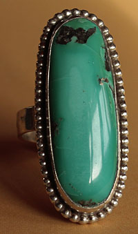 Une turquoise de dimension exceptionnelle est sertie sur cette bague longue western Country.