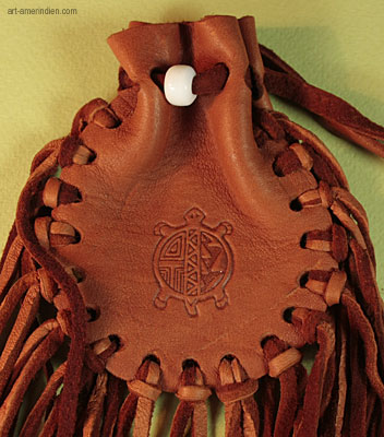 détail de la perle de verre blanc et du symbole amérindien de la tortue gravé sur ce medicine bag amérindien