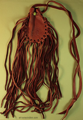 Ce medicine bag amérindien est réalisé en cuir d'élan très souple, il est orné de longues franges en cuir et d'une perle en verre verte
