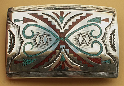 Boucle de ceinture américaine amérindienne Navajo en argent, motifs ethniques incrustés de turquoise et corail.