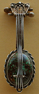 Cette broche en forme de guitare est un bijou amérindien ancien orné d'une turquoise rare.